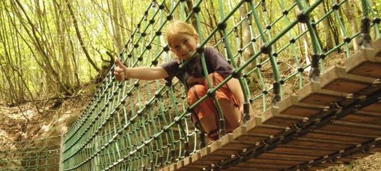 Kind auf Hängebrücke im Wald